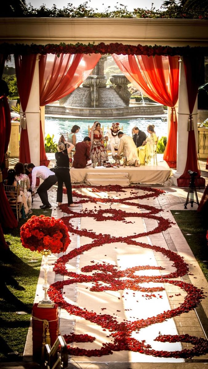 Red Rose Petal Wedding Aisle with Red Drapery and Garland – shared on Colin Cowie Weddings