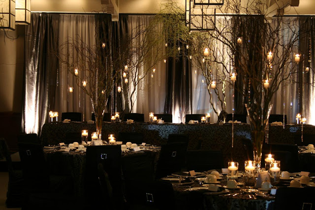 Branch Centerpiece with Candles and Crystal Accents over Black Tablecloth – shared by Wedding Design Studio