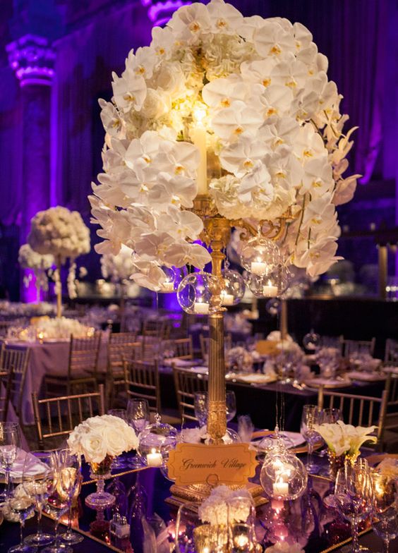 Gold Candlestick Centerpiece with Bubbling White Orchids – created by Colin Cowie Weddings