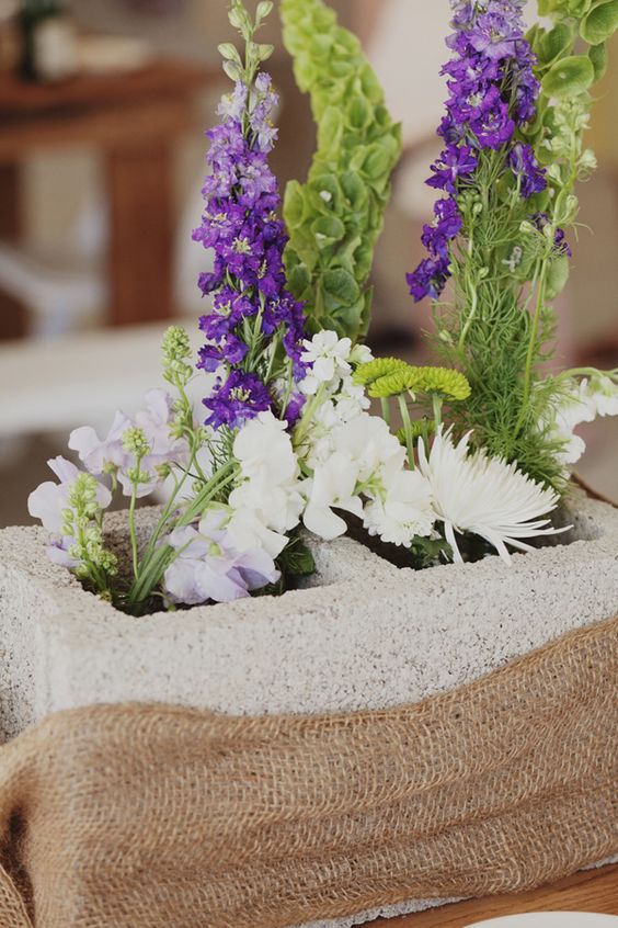 Concrete Block Centerpiece with Burlap Accents and Mixed Flowers – shared on Wedding Chicks