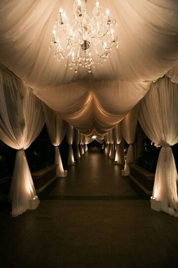 Grand Entrance with White Tent and Drapery featuring Crystal Chandeliers – shared by Inside Weddings