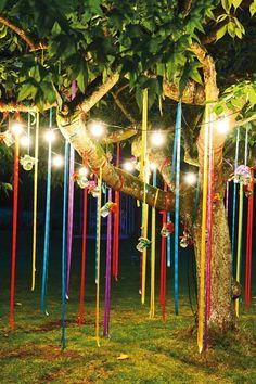 Colorful Outdoor Ribbons in a Tree with String Lights – shared in a roundup post by Decozilla