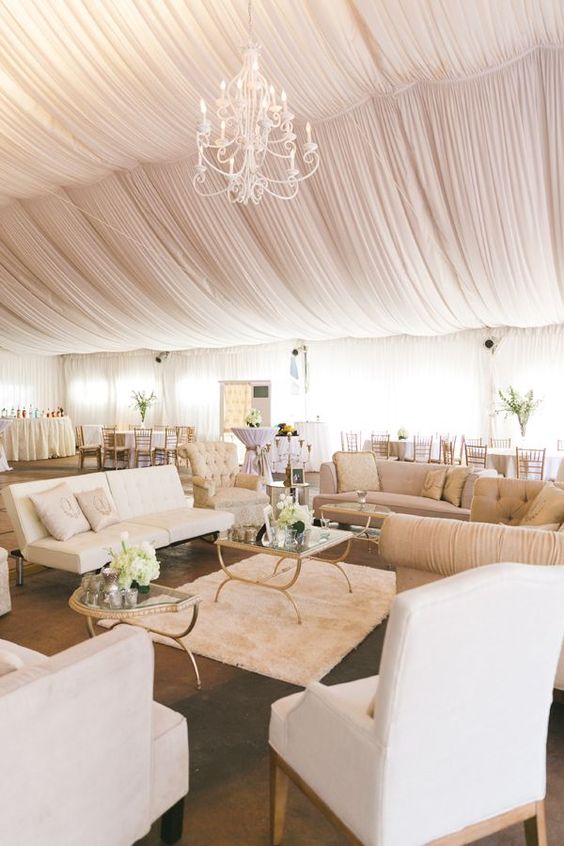 Blush and White Event Tent and Decor with Draped Ceilings, Lounge Groupings, and Chandelier – shared in a round up by MODWEDDING